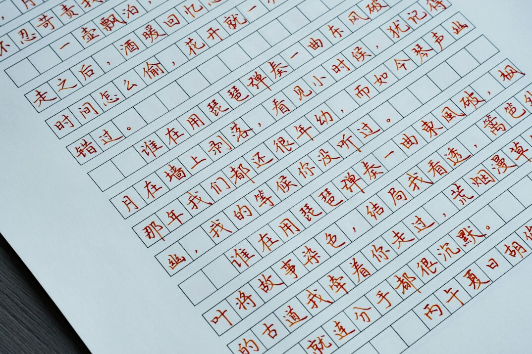 Developer reading printed code on paper with red pen annotations